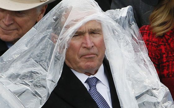 Former President George W. Bush keeps covered in the rain during Donald Trump's presidential inauguration Jan. 20, 2017, at the U.S. Capitol in Washington. (CNS/Reuters/Rick Wilking)