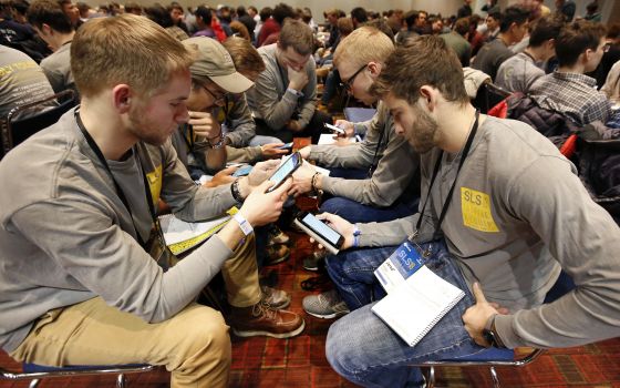 Students from the Diocese of Toledo, Ohio, look up Scripture passages on their cellphones during a group discussion Jan. 3 at a conference sponsored by the Fellowship of Catholic University Students in Chicago. (CNS/Karen Callaway, Chicago Catholic)