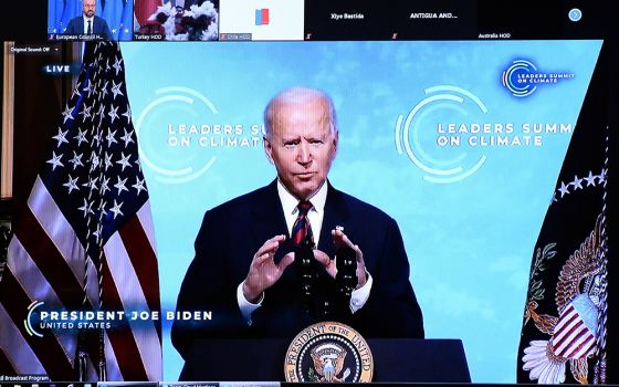 President Joe Biden is seen on a screen in Brussels, Belgium, April 22, 2021, as European Council President Charles Michel attends a virtual global climate summit. Biden committed the United States to cut greenhouse emissions in half by 2030. (CNS/Johanna