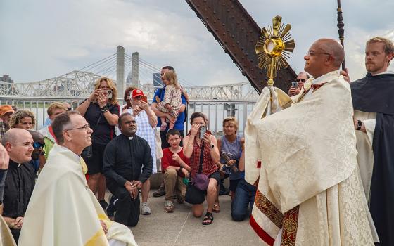Archbishop Shelton Fabre of Louisville, Kentucky, transfers the monstrance to Archbishop Charles Thompson of Indianapolis during a eucharistic procession across the Ohio River's Big Four Bridge July 9. The procession marked the end of the National Eucharistic Pilgrimage's route through the Louisville Archdiocese. The pilgrimage was making its way next through southern Indiana and into Indianapolis. (OSV News/The Record/Marnie McAllister)