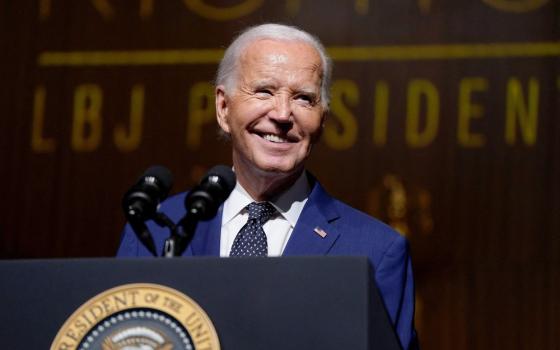 Biden smiles from behind podium. 