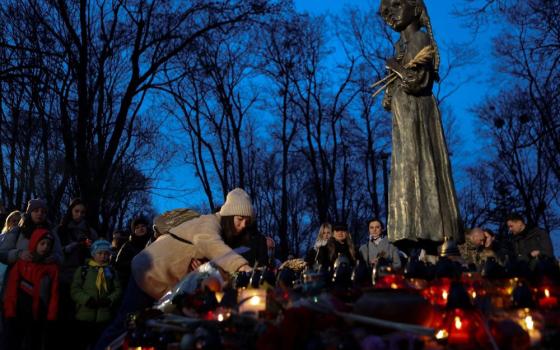 People visit a monument to Holodomor victims in Kyiv, Ukraine, Nov. 25, 2023, during a ceremony commemorating the famine of 1932-33.
