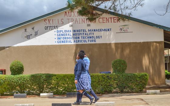 Girls walk by the Auxilium Skills Training Center in Makeni, Lusaka, Zambia. Along with the Home for Girls at Risk and the Open Community School, the center is part of City of Hope, run by the Salesian Sisters of St. John Bosco. (GSR photo/Derrick Silimina)