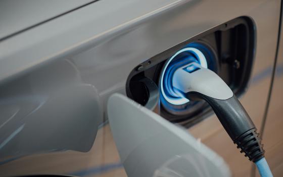 An photo illustration displays an electric vehicle charging. (Unsplash/CHUTTERSNAP)