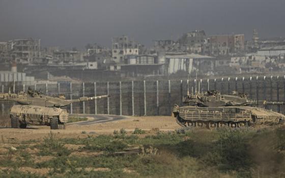 Tanks seen in foreground, border wall seen in background. 