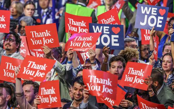 Attendees hold signs as President Joe Biden speaks during Day 1 of the Democratic National Convention in Chicago Aug. 19. (OSV News/Reuters/Mike Blake)