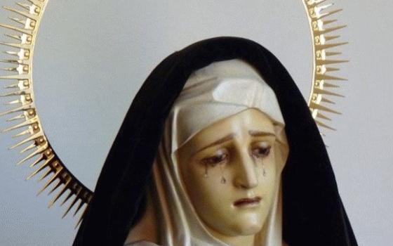 Upper portion of black-mantled, and haloed Virgin of Sorrows. 