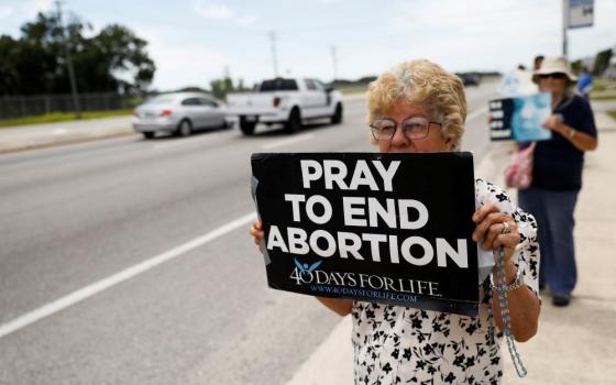 Woman holds pro-life sign.