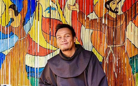 Franciscan Br. Christopher Villanueva of the Philippines in front of one of his artworks (Courtesy of Order of Friars Minor)