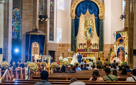 A young Filipino couple is married at the altar of Manila's Cathedral of the Immaculate Conception in the Philippines in 2023. (Dreamstime/Neil Bussey)