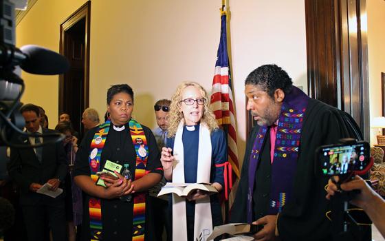 Butler seen with other faith leaders in corridor. 