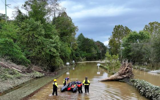 Group stands in middle of flooded area.