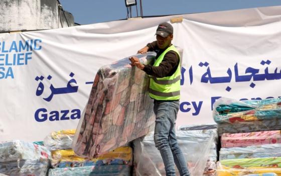 A humanitarian aid worker unloads mattresses supplied by Catholic Relief Services in Rafah, in the southern Gaza Strip, March 21. The mattresses will be distributed to people displaced in war-torn Gaza. (OSV News/Mohammad Al Hout for CRS)