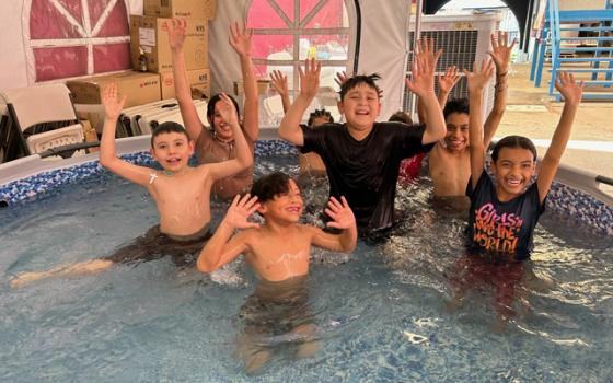 A group of children cool off in a plastic pool donated by California nonprofit Border Compassion to the Cobina Posada del Migrante shelter in Mexicali, Mexico, where temperatures reached 120 degrees July 8. The nonprofit, founded by Sr. Suzanne Jabro, a member of the Sisters of St. Joseph of Carondelet, organized a hot weather fund this summer to purchase plastic pools, popsicles, fruit and transportation to cooler venues for those at the shelter, which has no air conditioning. 