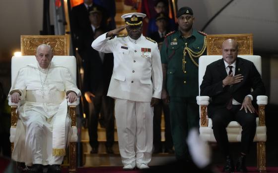 Pope Francis, left, is welcomed by Papua New Guinea's deputy Prime Minister John Rosso, right, and rear-Admiral Philip Polewara, center, as he arrives at Port Moresby's "Jackson" International Airport, Friday, Sept. 6, 2024. As a second leg of his 11-day trip to Asia and Oceania Pope Francis's visit to Papua New Guinea will take him to a remote part of the South Pacific island nation where Christianity is a recent addition to traditional spiritual beliefs developed over millennia.(AP Photo/Gregorio Borgia)