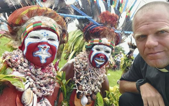 This undated photo provided by Fr. Tomas Ravaioli shows local villagers posing for a photo with him in Goroka, Papua New Guinea. (Fr. Tomas Ravaioli via AP)