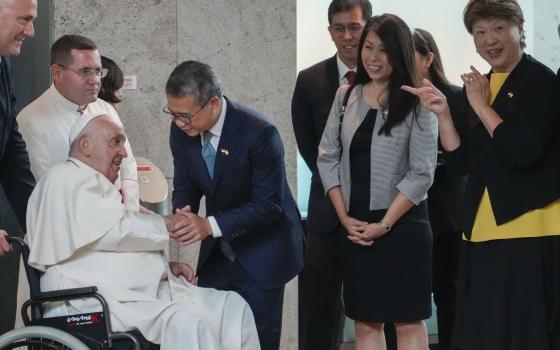 From left, Pope Francis is welcomed by Singapore's Minister of Culture, Community and Youth Edwin Tong and his wife (name not given) and the Ambassador of Singapore to the Holy See Ang Janet Guat Har as he arrives at Singapore Changi International Airport, Wednesday, Sept. 11, 2024. Pope Francis is heading to Singapore for the final leg of his 11-day trip to Asia and Oceania. (AP Photo/Gregorio Borgia)