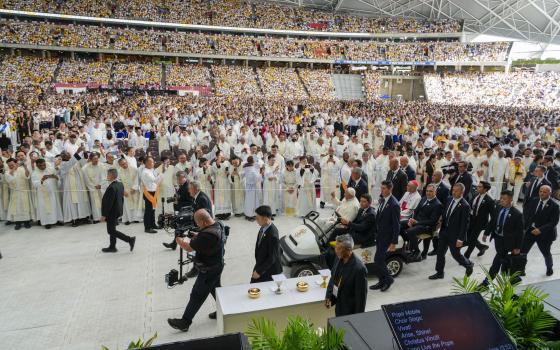 Faithful wait in the Singapore SportsHub National Stadium where Pope Francis will preside over a mass 'In Memory of the Most Holy Name of Mary' celebrated by the Archbishop of Singapore, Cardinal William Goh Seng Chye, center right, Thursday, Sept. 12, 2024. Pope Francis has praised Singapore's economic development as a testament to human ingenuity. But he's urging the city-state to look after the weakest too. Francis made the remarks Thursday on the final leg of the longest and farthest tour of his papacy.