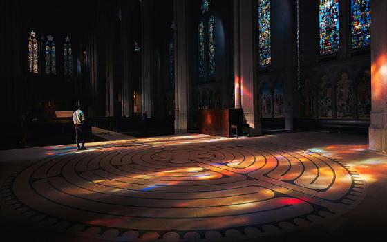 A person walks through a labyrinth in a church (Unsplash/Erez Attias)