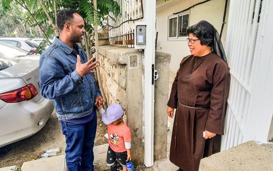 Franciscan Sister of the Eucharist Sr. Maria David Magbanua speaks with Abraham Rada as he comes to pick up his 2-year-old son Yonatan from the St. Rachel Center day care in Jerusalem after a day of work at a nearby minimarket. Rada, who arrived in Israel as a refugee from Eritrea in 2008, says the nuns at St. Rachel take care of Yonatan "like family." (Judith Sudilovsky)