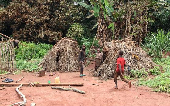 Baka young people are seen in a courtyard in front of traditional Baka huts known as mungulu in Elango village in Cameroon's East Region. (Angel Ngwe)