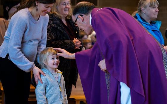 Fr. Bob Kabat, pastor of St. Matthew Parish in Allouez, Wis., distributes ashes to a young child during Ash Wednesday Mass, Feb. 14. Some 53% of American Catholics are "cultural Catholics" who attend Mass "a few times a year" or "seldom or never," while 47% attend monthly or more often. (OSV News/Sam Lucero)