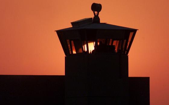 A file photo shows the sun setting behind one of the guard towers at the Federal Correctional Complex in Terre Haute, Indiana. The death chamber at the correctional facility is where the federal death penalty is carried out. (OSV News/Reuters/Andy Clark)