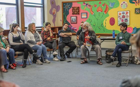 Jeromiah Taylor, right, and Brian Terrell, second from right, co-facilitate a roundtable discussion at the Peter Maurin Conference, which was held at St. Gregory's Hall in Chicago Sept. 6-8. (Mark Franzen)