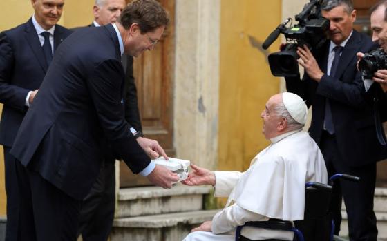 Ola Källenius, CEO of Mercedes-Benz, presents the key for the new all-electric popemobile to Pope Francis during a meeting at the Vatican Dec. 4. (CNS/Lola Gomez)