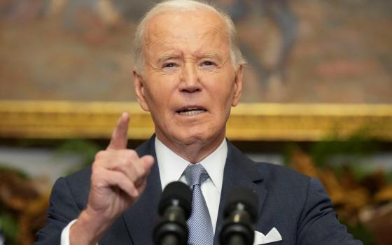 Biden standing at podium gestures while speaking.