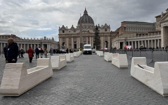 View of long path culminating in Basilica against gray sky.