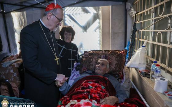 Cardinal Pierbattista Pizzaballa is seen Dec. 22, 2024, visiting an elderly Palestinian man sheltering on the premises of Holy Family Catholic Parish in Gaza City in the war-torn Gaza Strip. The cardinal made a pre-Christmas visit aiming to bring the joy of the season to the suffering Christian community in the 14th month of Israel-Hamas war. (OSV News photo/courtesy Latin Patriarchate of Jerusalem)