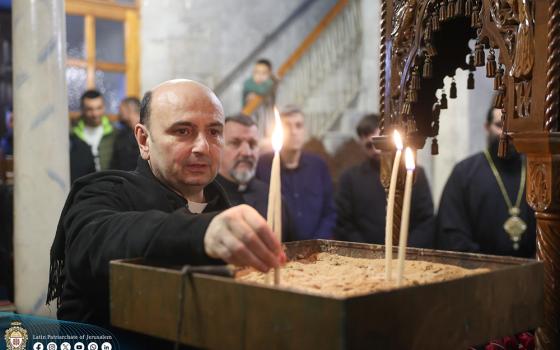 Fr. Gabriel Romanelli, parish priest of Holy Family Church in Gaza City, lights a candle Dec. 22, 2024. (OSV News/Courtesy of Latin Patriarchate of Jerusalem)