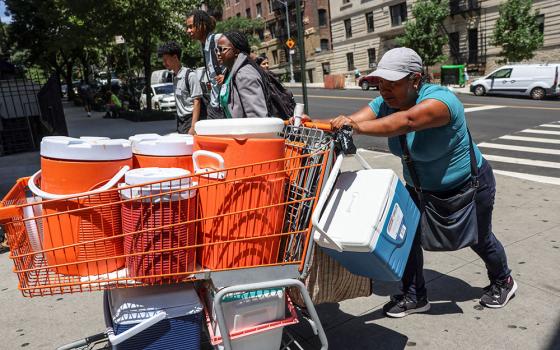 A woman pushes a shopping cart full of coolers and cold beverages during a summer heatwave in New York City July 11, 2024. Seventeen U.S. states set annual heat records in 2024, the hottest year to date. (OSV News/Reuters/Caitlin Ochs)