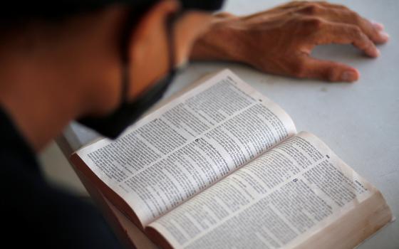 A Central American migrant who was deported by U.S. and Mexican officials reads the Bible at a shelter in El Ceibo, Guatemala, on Aug. 15, 2021. (CNS/Reuters/Luis Echeverria)