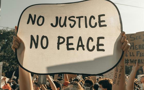 A sign that says "No Justice, No Peace" (Unsplash/Clay Banks)