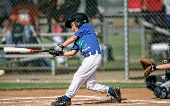 Boy swings baseball bat.