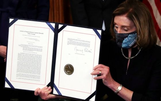 House Speaker Nancy Pelosi, D-Calif., shows the article of impeachment against President Donald Trump after signing it in an engrossment ceremony at the U.S. Capitol in Washington Jan. 13, 2021. (CNS/Reuters/Leah Millis)