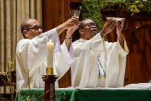 Oblate Fr. Fenelon Sylfrard, right, and Deacon Hernst Bellevue elevate the Eucharist during Sunday Mass at St. Martha Church in Uniondale, New York, in 2021. (CNS/Gregory A. Shemitz)