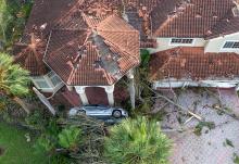 Damage is seen to a home and car Oct. 10 in Wellington, Florida, after a tornado formed by Hurricane Milton touched down striking homes in the neighborhood and surrounding area. (OSV News/USA Today Network via Reuters/Palm Beach Post/Greg Lovett)